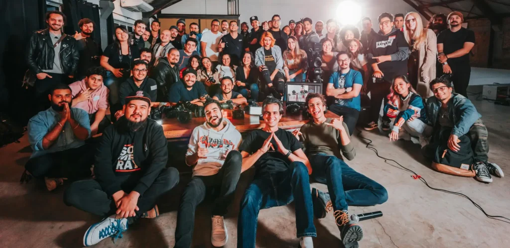 A happy and diverse group posing together in a São Paulo warehouse setting.